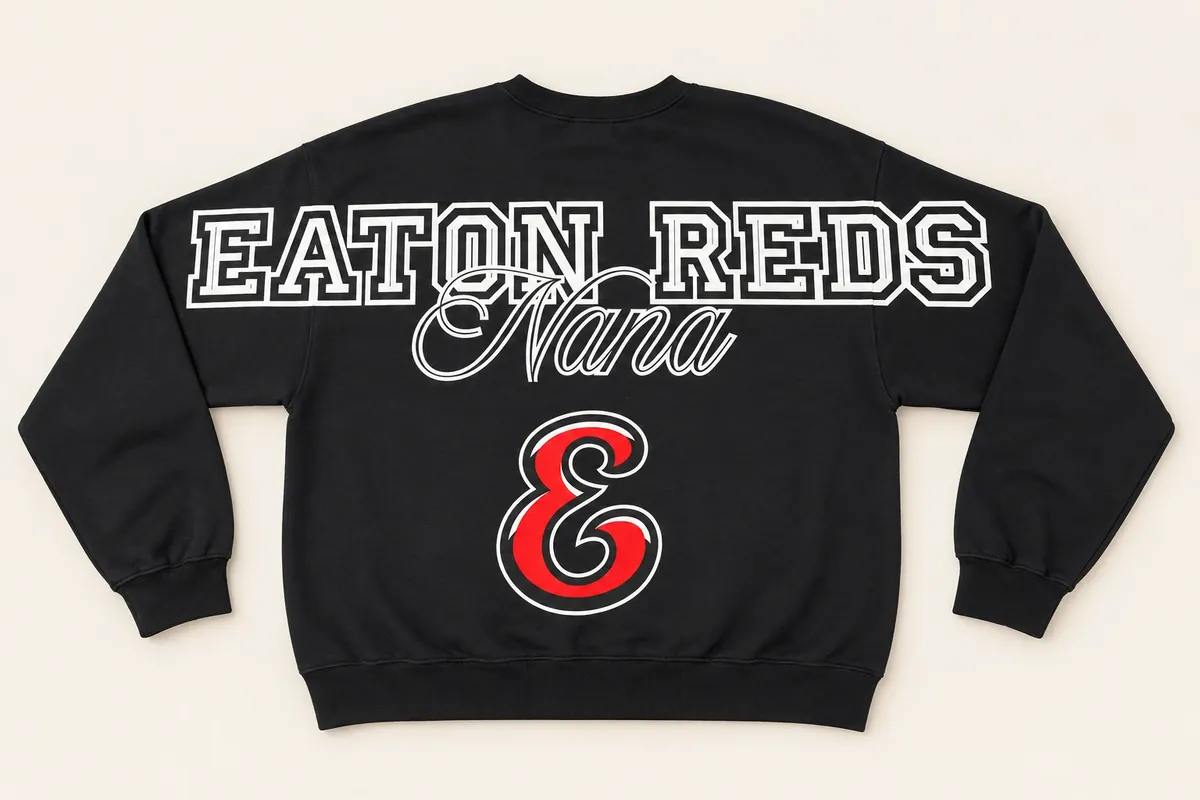 Back of a black crewneck sweatshirt: EATON REDS across the shoulders and sleeves, Nana in script, and a large red team E
